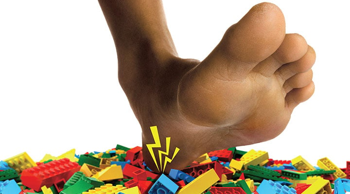 Image of a foot in pain stepping on a pile of legos